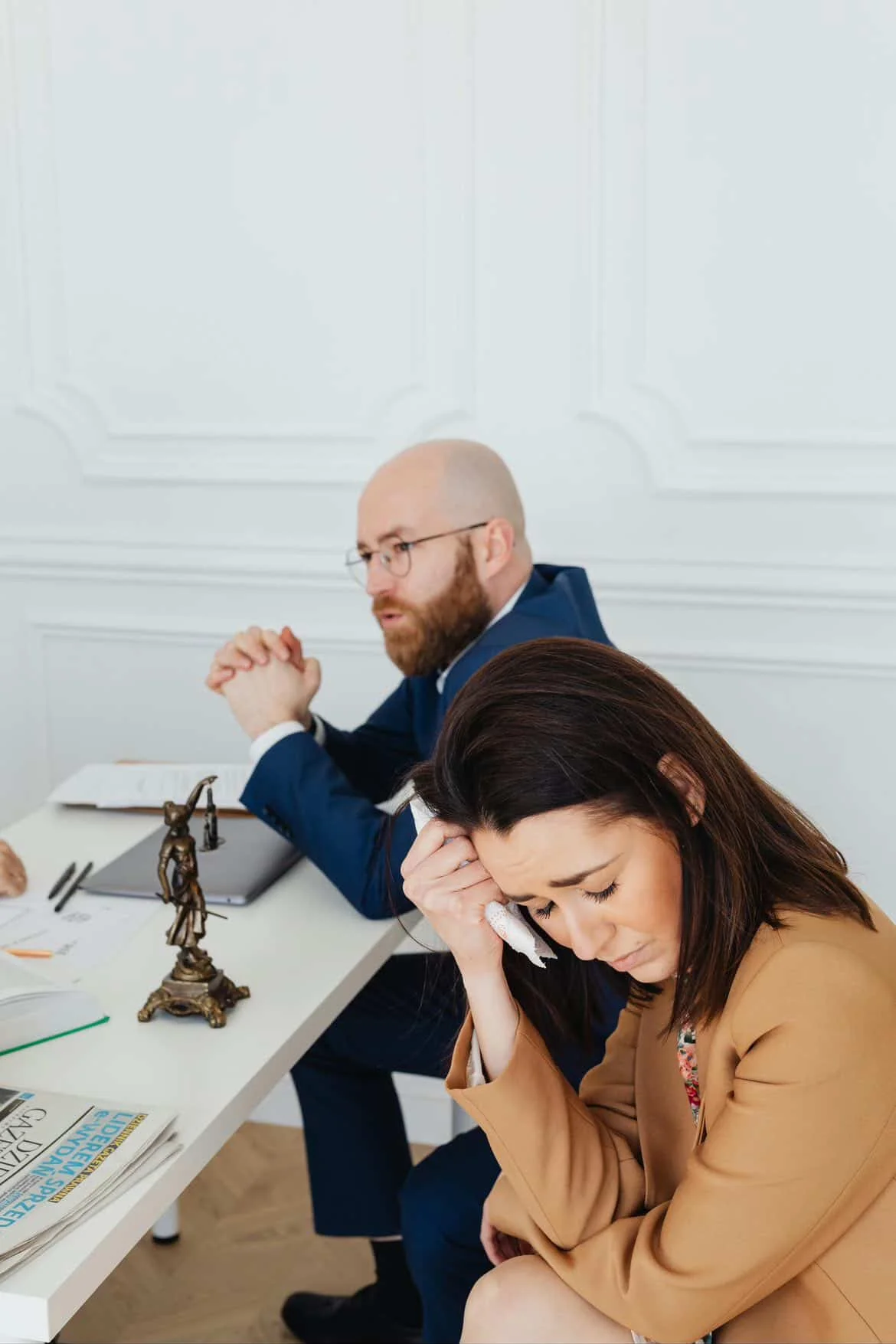 Divorce case investigation consultation with a distressed woman and private investigator discussing legal evidence in office